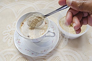 Adding Brown Sugar To Tea Cup