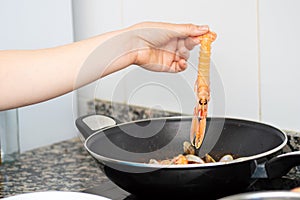 Adding a crayfish to the wok