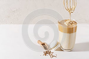 Adding foam in Dalgon coffee in a glass beaker on a light background