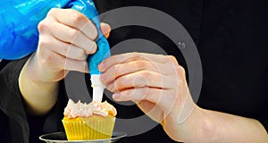 Adding frosting to a cupcake