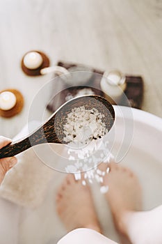 Adding Magnesium Chloride vitamin salt in foot bath water, solution. Magnesium grains in foot bath water . photo