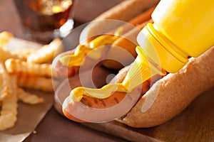 Adding mustard to grilled hot dog