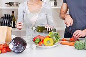 Adding olive oil while cooking salad photo