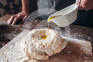 Adding olive oil to raw dough close-up
