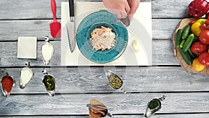 Adding parmesan cheese to pasta.