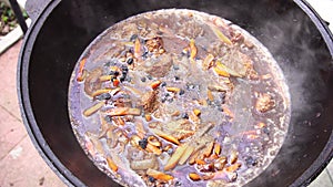 Adding raisins to meat, carrots and onions when stewing Uzbek pilaf