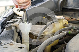 Adding windshield washer fluid at gasolin station by driver. Close-up of adding windshield washer fluid on a car. car