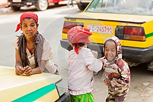 Three small orphan street kids playing and laughing on a quite c