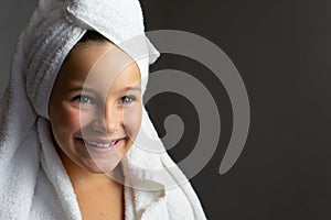 Addorable little girl happy smiling after spa bath on a white bath towel head