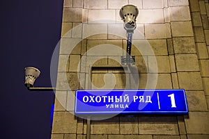 Address plate with the inscription `Okhotny Ryad Street 1` on the building of the State Duma. Winter evening, Moscow, Russia.