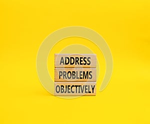 Address Problems Objectively symbol. Wooden blocks with words Address Problems Objectively. Beautiful yellow background. Business