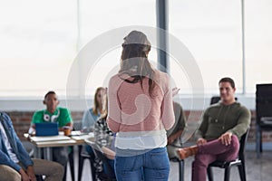 Addressing her group. Rearview shot of young university student addressing her class during a lesson.