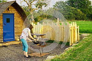 Adele cooking scrambled egg, via a firepit whilst glamping, in Cumbria.