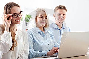 An adept businesswoman is providing guidance and teaching to junior workers in the office.