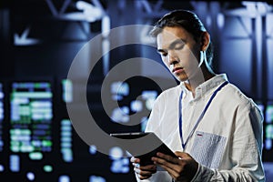 Programmer in data center with tablet