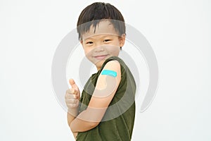 Adhesive bandage on arm after covid-19 vaccination,Thump up, Little kid showing his arm with bandage