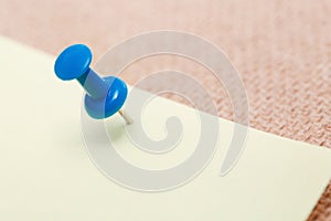 Adhesive note and blue pushpin