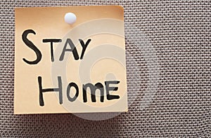 Adhesive note with Stay Home text on a bulletin board