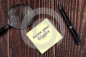 Adhesive note with text know your triggers