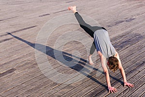 Adho Mukha Svanasana practiced by a young outdoor yoga enthusiast in the city photo