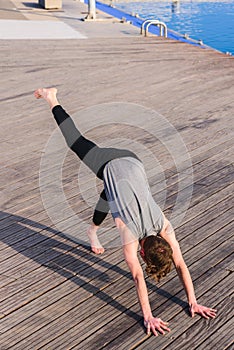 Adho Mukha Svanasana practiced by a young outdoor yoga enthusiast in the city photo