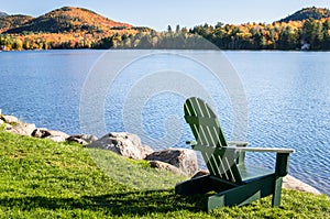 Adirondack Chair Facing a Mountain Lake on a Sunny Morning photo