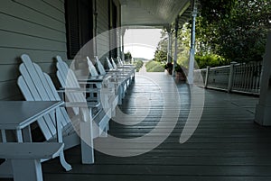 Adirondack chairs lines up on a porch