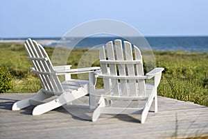 Adirondack chairs overlooking beach.