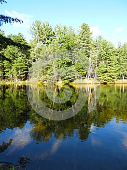 Adirondack lake reflection under blue sky late summer