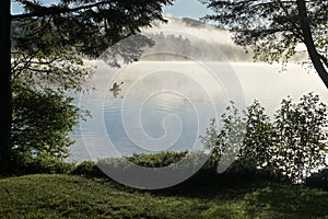 Adirondack Park, New York, USA: A kayaker paddles across Sagamore Lake