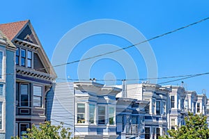 Adjacent residential buildings with victorian style against the clear sky in San Francisco, CA