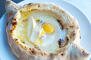 Adjarian khachapuri with eggs and butter on the table