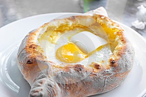 Adjarian khachapuri with eggs and butter on the table