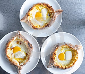 Adjarian khachapuri with eggs and butter on the table