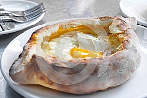 Adjarian khachapuri with eggs and butter on the table