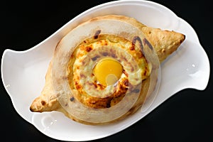 Adjarian khachapuri with eggs on the table.