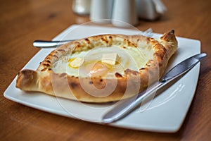 Adjarian khachapuri with eggs on the table