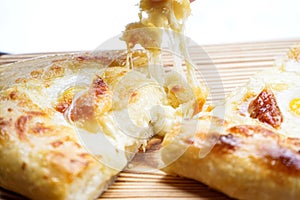 Adjarian Khachapuri with quail eggs and cheese on a wooden board. Close-up