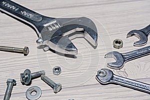 Adjustable and ordinary spanners, nuts and bolts on the table