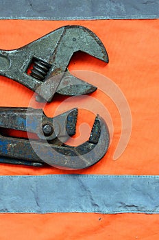 Adjustable and pipe wrenches against the background of an orange