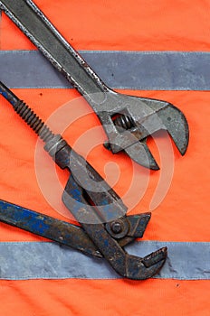Adjustable and pipe wrenches against the background of an orange