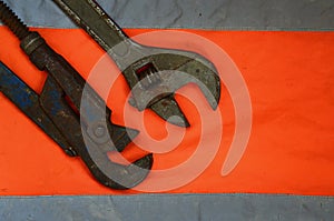 Adjustable and pipe wrenches against the background of an orange