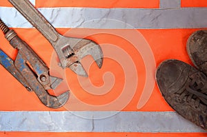 Adjustable and pipe wrenches against the background of an orange