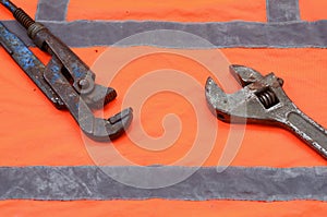 Adjustable and pipe wrenches against the background of an orange