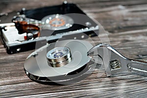 An adjustable spanner wrench and HDD platters together, hard disk drive disassembled damaged components, computer maintenance,