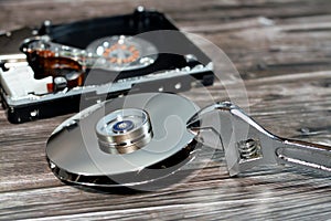 An adjustable spanner wrench and HDD platters together, hard disk drive disassembled damaged components, computer maintenance,