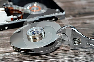 An adjustable spanner wrench and HDD platters together, hard disk drive disassembled damaged components, computer maintenance,
