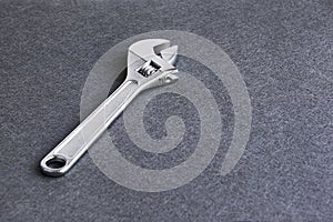 Adjustable wrench in grey background