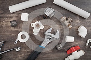 Adjustable wrench, plumbers tools and materials on the wooden background
