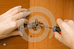 Adjusting a cabinet door hinge